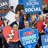 Group of people with 'Stop, Think, Check' signs.